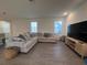Cozy living room featuring a large sectional sofa, stylish decor, and wood-look tile flooring at 9787 Introduction Way, Orlando, FL 32832