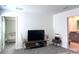 This living room leads to a bedroom and bathroom and has a TV, decorations, carpet, and white walls at 9787 Introduction Way, Orlando, FL 32832