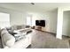 Spacious living room with a large sofa, modern TV stand, and tile flooring throughout at 9787 Introduction Way, Orlando, FL 32832