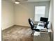 This office has carpet, a ceiling fan, a window with blinds, a computer, and a black office chair at 9787 Introduction Way, Orlando, FL 32832