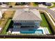 Backyard aerial view features a pool, patio, and manicured lawn enclosed by fencing and neighboring properties at 10032 Brocksport Cir, Gotha, FL 34734