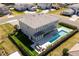 Aerial of a modern home with a pool, manicured lawn, and outdoor seating area at 10032 Brocksport Cir, Gotha, FL 34734