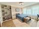 Cozy bedroom featuring a queen-size bed, natural light, built-in shelving, and wood floors at 10032 Brocksport Cir, Gotha, FL 34734