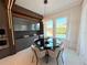 Modern dining area features a black round table, stylish chairs, and a view of the pool through the windows at 10032 Brocksport Cir, Gotha, FL 34734