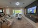Open-concept living room with modern furniture, television, decor and a sliding glass door to outdoor patio at 10032 Brocksport Cir, Gotha, FL 34734