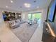 Open-concept living room showcasing modern furniture, area rug, decor and a sliding glass door to outdoor patio at 10032 Brocksport Cir, Gotha, FL 34734