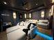 Home theater with tiered seating, plush sofas, ambient lighting, and Star Wars decor at 10032 Brocksport Cir, Gotha, FL 34734