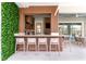 Outdoor kitchen with bar seating, marble countertops, and a view of the yard, perfect for entertaining at 10032 Brocksport Cir, Gotha, FL 34734