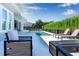 Outdoor lounge area with fireplace and in-ground pool, all surrounded by lush landscaping, creating a private retreat at 10032 Brocksport Cir, Gotha, FL 34734