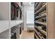 Well-organized walk-in closet with custom shelving for shoes and hanging clothes at 10032 Brocksport Cir, Gotha, FL 34734
