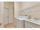 Functional laundry room with washer, dryer, sink, and ample shelving at 1187 Tadsworth Ter, Lake Mary, FL 32746