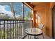 Cozy screened-in balcony with a small table and a chair overlooking a parking lot at 12527 Floridays Resort Dr # E-111, Orlando, FL 32821