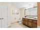 Bright bathroom featuring a wood vanity with granite countertop and a neutral color palette at 12527 Floridays Resort Dr # E-111, Orlando, FL 32821