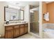 Bathroom featuring granite countertops, wood cabinetry, a walk-in shower, and a soaking tub at 12527 Floridays Resort Dr # E-111, Orlando, FL 32821
