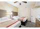 Comfortable bedroom featuring two queen beds, ceiling fan, and ample natural light at 12527 Floridays Resort Dr # E-111, Orlando, FL 32821