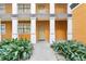 Close up of a condo entrance, showcasing the building's exterior features and tidy landscaping at 12527 Floridays Resort Dr # E-111, Orlando, FL 32821