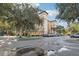 Angle view of the building complex and parking with lush landscaping on a sunny day at 12527 Floridays Resort Dr # E-111, Orlando, FL 32821