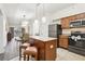 Modern kitchen with stainless steel appliances, granite countertops, and an island with seating at 12527 Floridays Resort Dr # E-111, Orlando, FL 32821