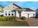 Charming single-Gathering home featuring a two-car garage, brick driveway, and a welcoming front porch with a decorative wreath at 13059 Stoddart Ave, Orlando, FL 32827