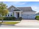 Charming home with a three-car garage, stone accents, and a well-manicured front yard at 13059 Stoddart Ave, Orlando, FL 32827