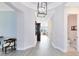 Hallway with gray wood floors leads to a spacious living area with view at 13059 Stoddart Ave, Orlando, FL 32827
