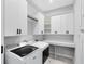 Modern laundry room with white cabinets, countertop, and front loading washer and dryer at 13059 Stoddart Ave, Orlando, FL 32827