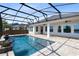 Beautifully appointed in-ground pool with water features and a screened enclosure overlooking the lake at 13059 Stoddart Ave, Orlando, FL 32827