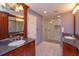 Well-lit bathroom with granite countertop, dual sinks, framed mirror, and a glass-enclosed walk-in shower at 1322 Ensenada Dr, Orlando, FL 32825