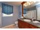 Bathroom with a blue textured wall, vanity with granite countertop, and a framed mirror at 1322 Ensenada Dr, Orlando, FL 32825