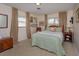 Cozy bedroom with a floral bedspread, beige carpet and walls, and framed photos on the wall at 1322 Ensenada Dr, Orlando, FL 32825