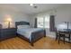 Bright bedroom features a dark wood bed frame, matching desk, and light wood flooring at 1322 Ensenada Dr, Orlando, FL 32825
