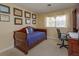 Comfortable bedroom with a daybed, wooden desk, diplomas, and a bright window at 1322 Ensenada Dr, Orlando, FL 32825