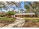 Charming one-story brick home with a lush front yard, long driveway and mature shade trees at 1322 Ensenada Dr, Orlando, FL 32825