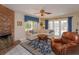 A cozy living room with a brick fireplace, area rug, and a view to the pool through sliding glass doors at 1322 Ensenada Dr, Orlando, FL 32825