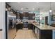 Modern kitchen boasts dark cabinetry, stainless steel appliances, and a granite countertop island with a sink at 1325 Seburn Rd, Apopka, FL 32703