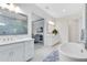 Bright bathroom featuring dual vanities, a soaking tub, and a glass-enclosed shower at 13346 Alderley Dr, Orlando, FL 32832
