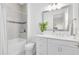 Clean bathroom featuring a single vanity, stylish mirror, and a tub/shower combo with tiled walls at 13346 Alderley Dr, Orlando, FL 32832
