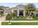 A lovely stone front exterior with a well-manicured lawn and tropical landscaping at 13346 Alderley Dr, Orlando, FL 32832