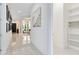 Bright hallway featuring white tile floors, neutral walls, artwork and clear views of multiple rooms at 13346 Alderley Dr, Orlando, FL 32832