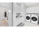 A bright laundry room featuring white shaker cabinets, granite countertops, sink and modern washer and dryer at 13346 Alderley Dr, Orlando, FL 32832