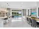 Open-concept living and dining areas, leading from the kitchen to the outdoor pool area with a TV at 13346 Alderley Dr, Orlando, FL 32832