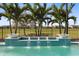 Stunning pool featuring turquoise tile, white water bowls, and a lush backdrop of palm trees and greenery at 13346 Alderley Dr, Orlando, FL 32832