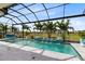 A stunning screened-in pool with water features, palm trees, and outdoor seating with a relaxing view at 13346 Alderley Dr, Orlando, FL 32832