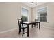 Dining room featuring a dark wooden table and black chairs with two windows bringing in natural light at 14500 Black Quill Dr, Winter Garden, FL 34787