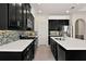 Modern kitchen boasting black cabinets, quartz countertops, stainless steel appliances, and a mosaic backsplash at 14500 Black Quill Dr, Winter Garden, FL 34787