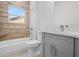 Modern bathroom has wood-look accent wall, a gray vanity, and a window at 14750 Sw 63Rd Ter, Ocala, FL 34473