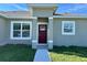 Close-up shot of a red front door, framed by white trim and large window at 14750 Sw 63Rd Ter, Ocala, FL 34473