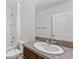 Bathroom with a single sink vanity, granite counters, and a shower over tub combo at 16140 Yelloweyed Dr, Clermont, FL 34714