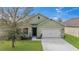 Charming single-story home with a well-manicured lawn and a two-car garage at 16140 Yelloweyed Dr, Clermont, FL 34714