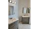 Bright bathroom featuring double vanities, wood cabinetry, and modern mirrors at 1623 Bridgeview Cir, Orlando, FL 32824